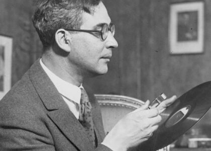 From 1924, Cleveland Orchestra conductor Nikolai Sokoloff inspects the Orchestra's very first recording with a magnifying class.